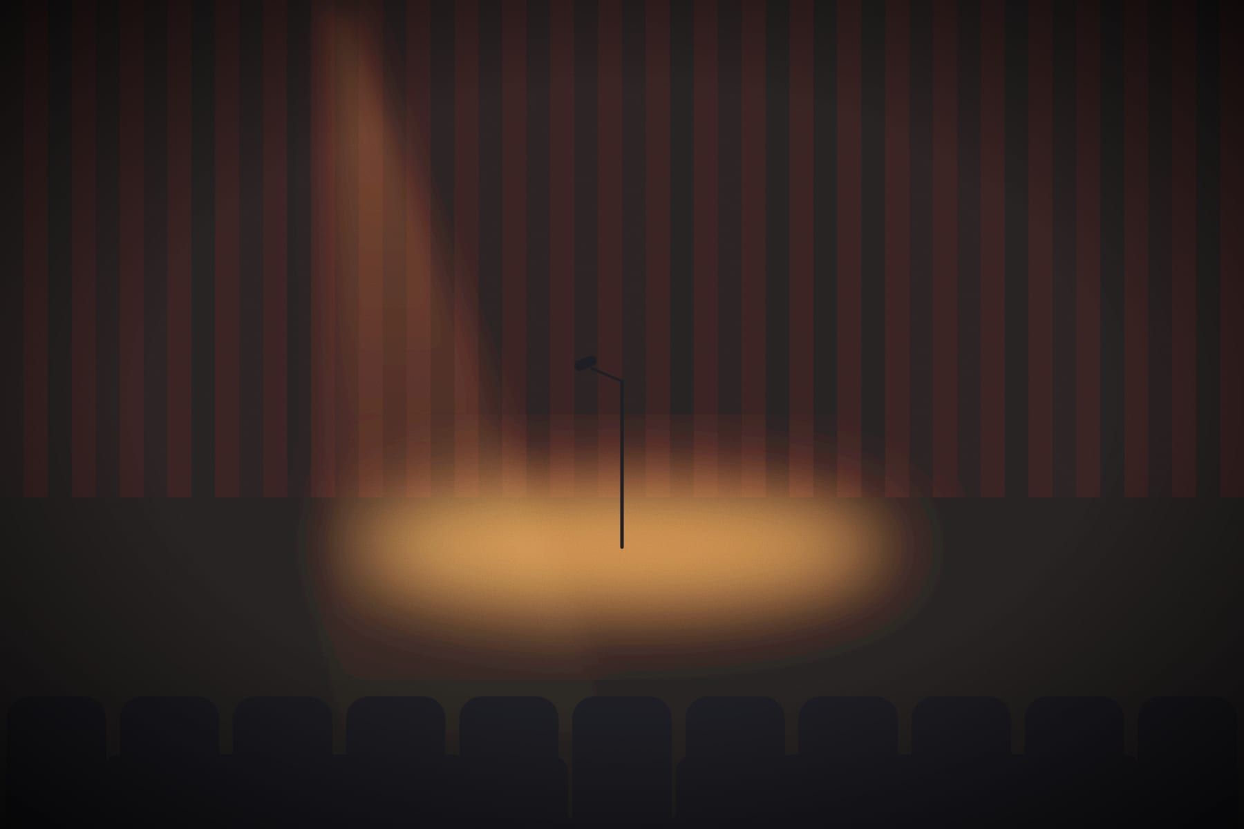 A single microphone stand in a spotlight